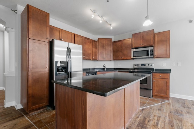 kitchen featuring sink, decorative light fixtures, dark hardwood / wood-style flooring, a kitchen island, and stainless steel appliances