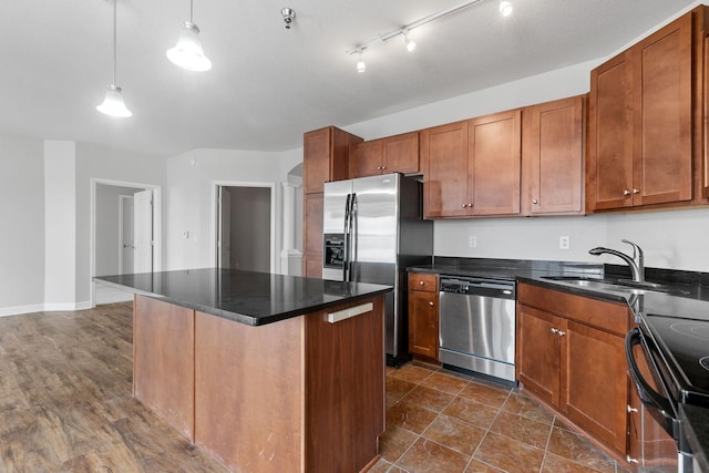 kitchen with a kitchen island, decorative light fixtures, decorative columns, sink, and stainless steel appliances