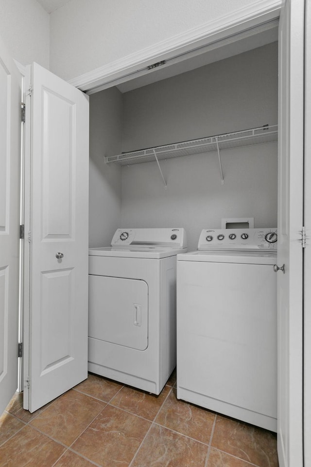 laundry room with light tile patterned floors and washing machine and clothes dryer