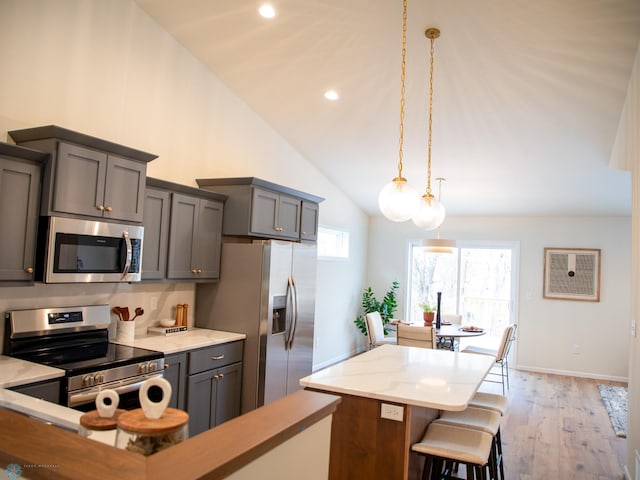 kitchen featuring gray cabinetry, decorative light fixtures, light hardwood / wood-style floors, and appliances with stainless steel finishes