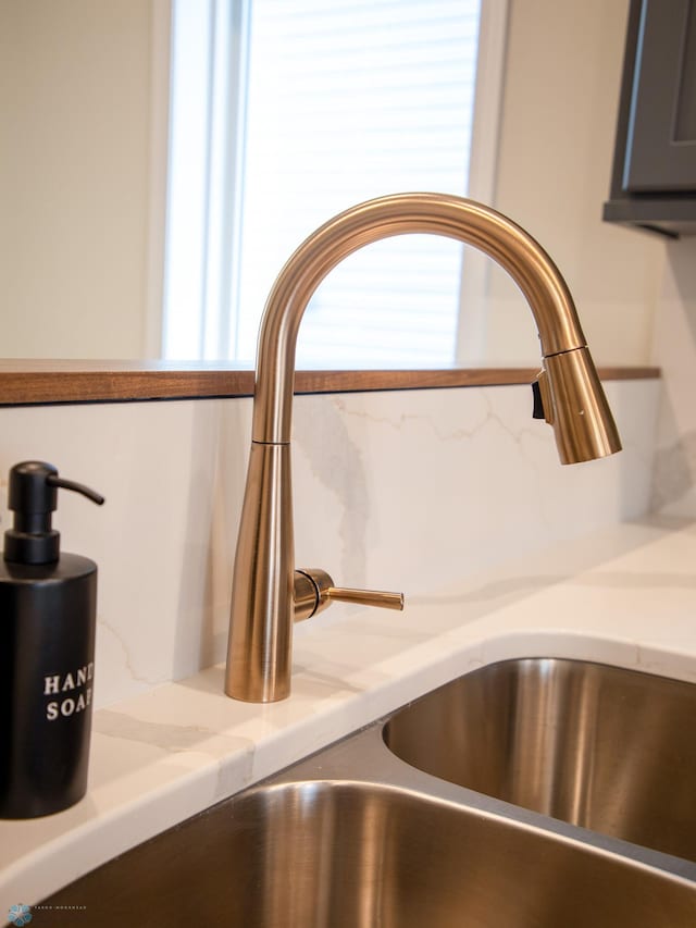 details with light stone countertops and sink