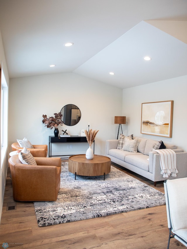 living room with wood-type flooring and vaulted ceiling