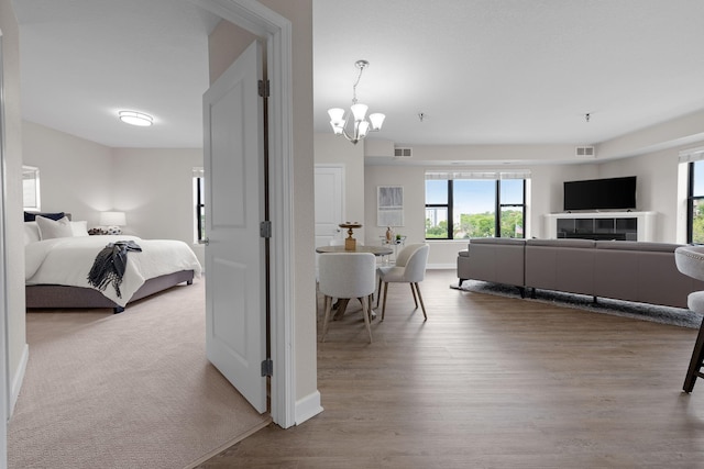 bedroom featuring light wood-type flooring and an inviting chandelier