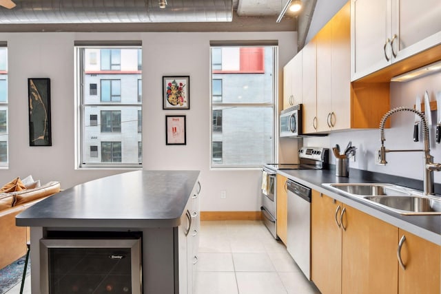 kitchen featuring plenty of natural light, beverage cooler, sink, and appliances with stainless steel finishes