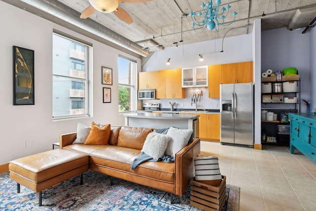 living room featuring light tile patterned flooring, track lighting, ceiling fan, and sink