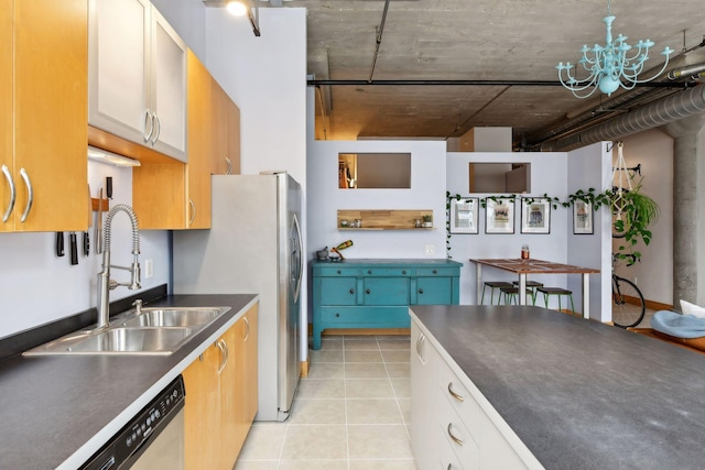 kitchen with sink, white cabinets, light tile patterned floors, and a notable chandelier