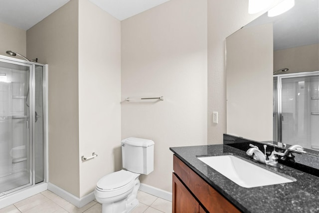 bathroom with vanity, toilet, a shower with door, and tile patterned flooring