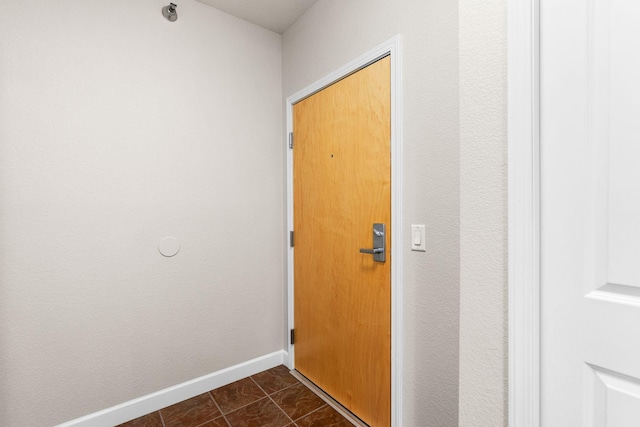 hall featuring dark tile patterned floors