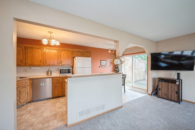 14962 Dodd Blvd, Rosemount, MN 55068 - kitchen with appliances with stainless steel finishes, brown cabinetry, light countertops, and a chandelier