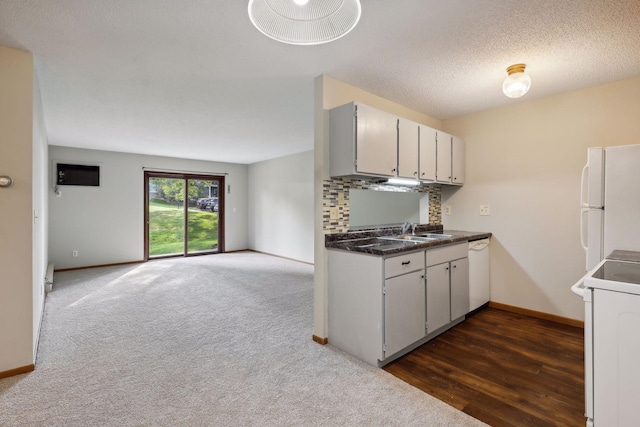 kitchen featuring a wall mounted air conditioner, dark carpet, a textured ceiling, white appliances, and sink