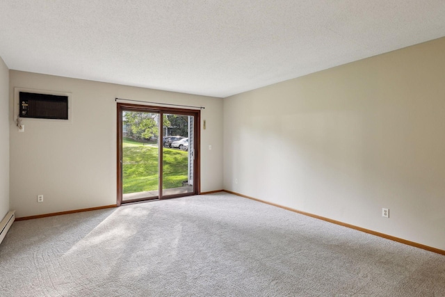 spare room featuring carpet flooring, a wall unit AC, and a textured ceiling