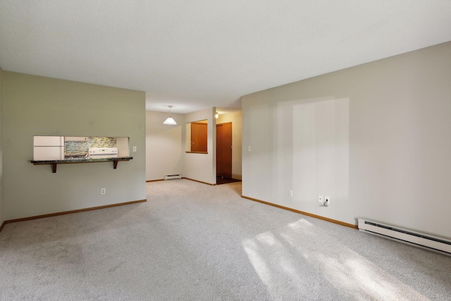 spare room featuring light carpet and a baseboard heating unit