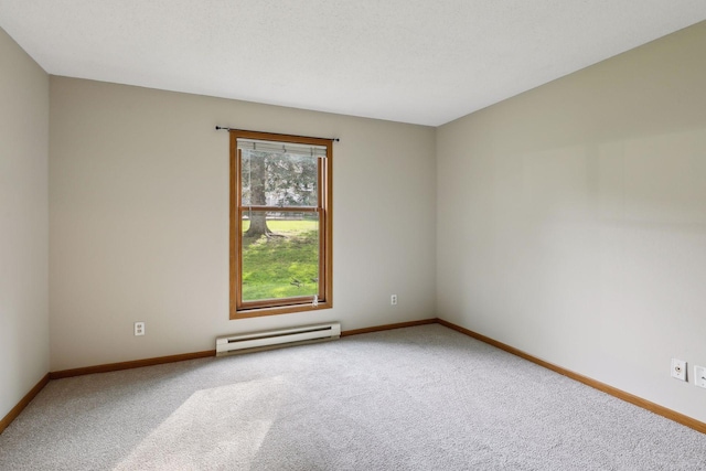 carpeted spare room featuring a baseboard heating unit