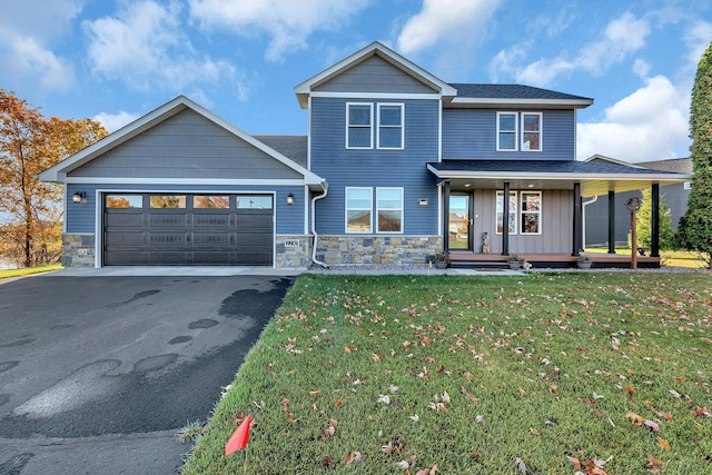 view of front of home with a garage, covered porch, and a front lawn