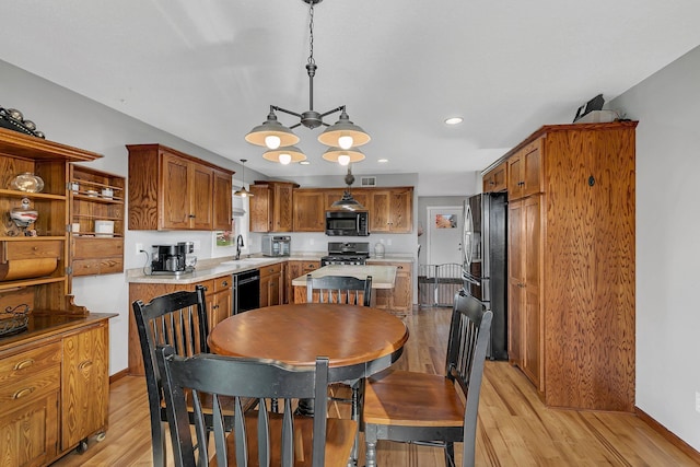 dining space featuring sink, an inviting chandelier, and light hardwood / wood-style floors