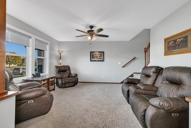 carpeted living room with a textured ceiling and ceiling fan