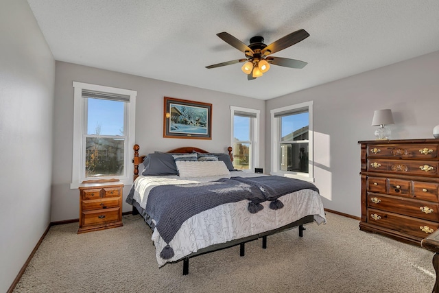 bedroom with light colored carpet, a textured ceiling, and ceiling fan