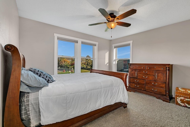 carpeted bedroom with a textured ceiling and ceiling fan