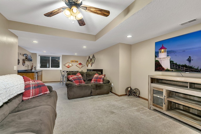 carpeted living room with ceiling fan, sink, and a textured ceiling