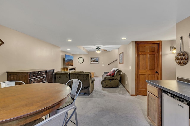 dining space with ceiling fan and light colored carpet