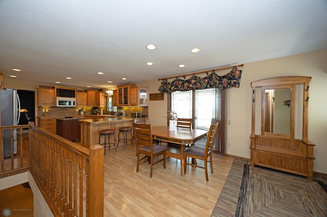 dining area with sink and light hardwood / wood-style floors