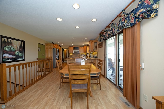 dining space with light hardwood / wood-style floors