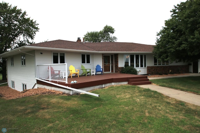 back of house featuring a deck and a lawn