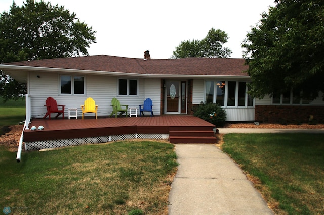 ranch-style house featuring a deck and a front lawn