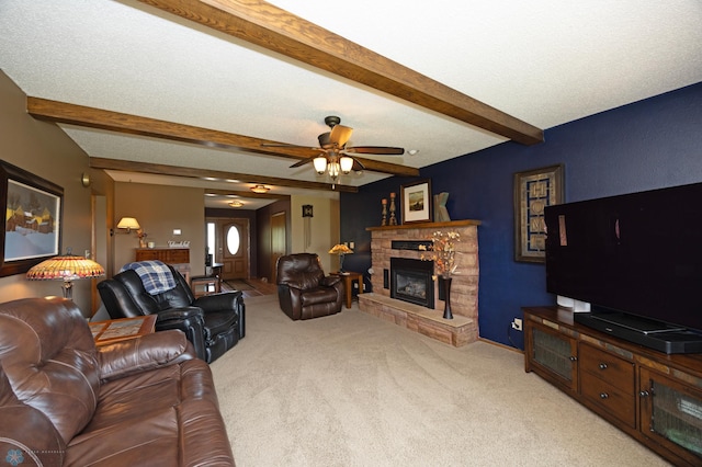 living room featuring beamed ceiling, a stone fireplace, carpet floors, and a textured ceiling