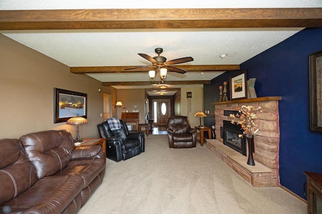 living room featuring beamed ceiling, a stone fireplace, carpet, and a textured ceiling