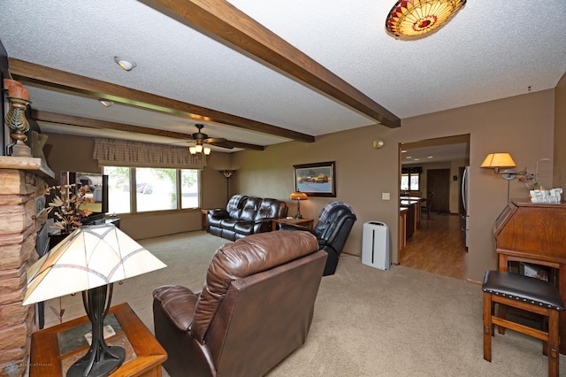 living room with beamed ceiling, ceiling fan, light carpet, and a textured ceiling