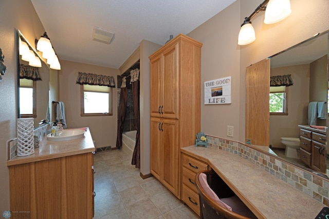 full bathroom featuring shower / tub combo with curtain, tile patterned floors, toilet, tasteful backsplash, and vanity