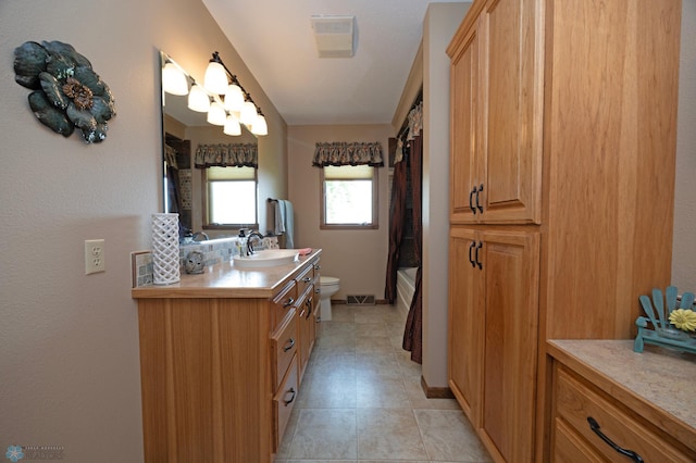 full bathroom with vanity, shower / bathtub combination with curtain, tile patterned floors, and toilet