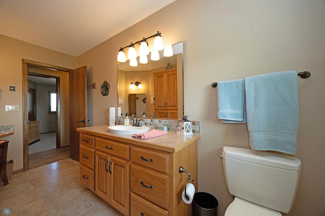 bathroom featuring tasteful backsplash, vanity, toilet, and tile patterned flooring