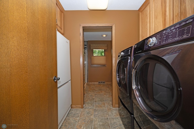 washroom featuring cabinets and independent washer and dryer