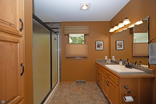 bathroom featuring an enclosed shower and vanity