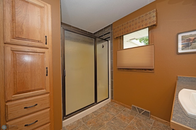 bathroom with vanity and a shower with shower door