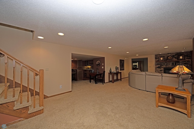 carpeted living room with a fireplace and a textured ceiling