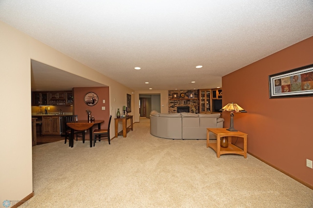 living room with bar, light carpet, a textured ceiling, and a fireplace