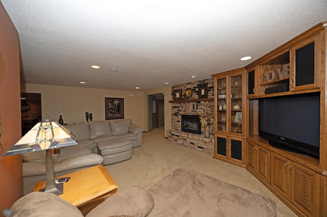 living room featuring a fireplace, light colored carpet, and a textured ceiling