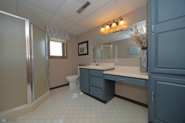 bathroom with vanity, a paneled ceiling, an enclosed shower, and toilet