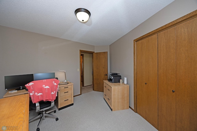 home office featuring light carpet and a textured ceiling