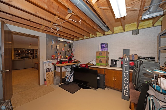 office space featuring brick wall and a workshop area