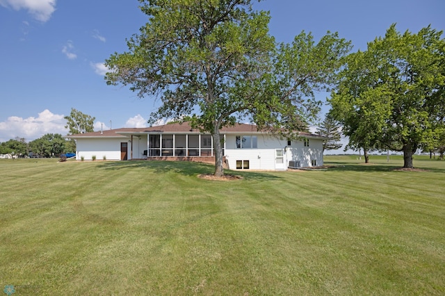 rear view of property with a yard and a sunroom