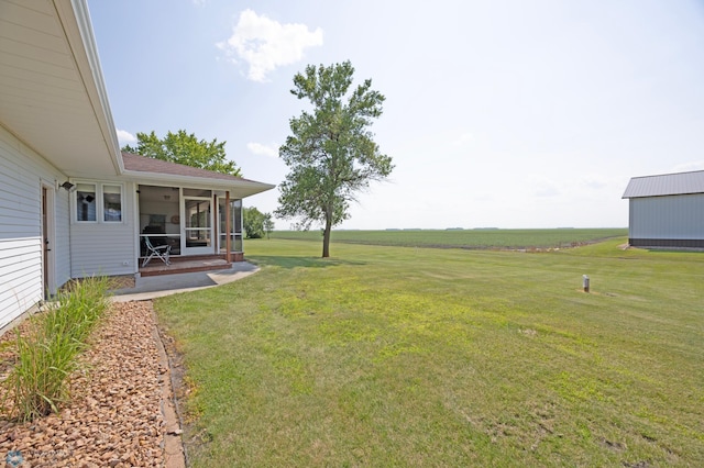 view of yard with a rural view and a sunroom