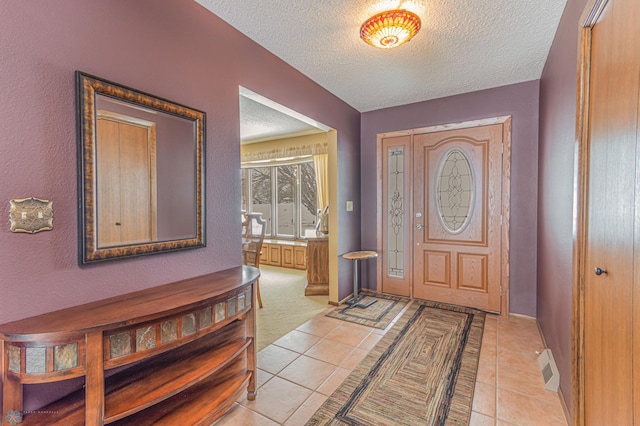 entrance foyer featuring a textured ceiling and light tile patterned floors