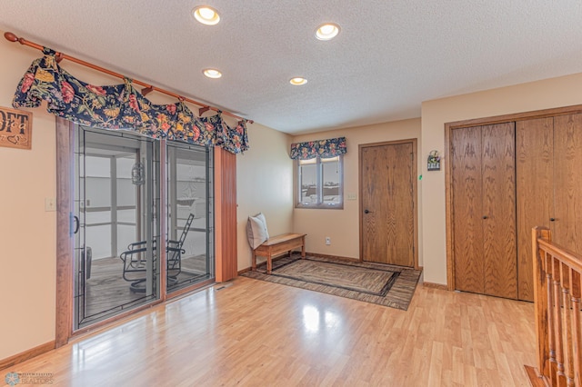 entrance foyer featuring a textured ceiling and light wood-type flooring