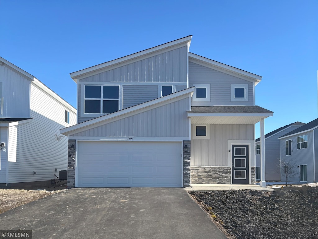 view of front of property with a garage and central air condition unit