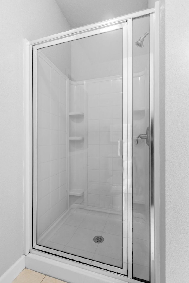 bathroom featuring tile patterned flooring and a shower with door