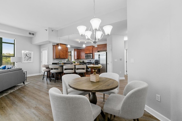 dining room with a notable chandelier and light hardwood / wood-style flooring